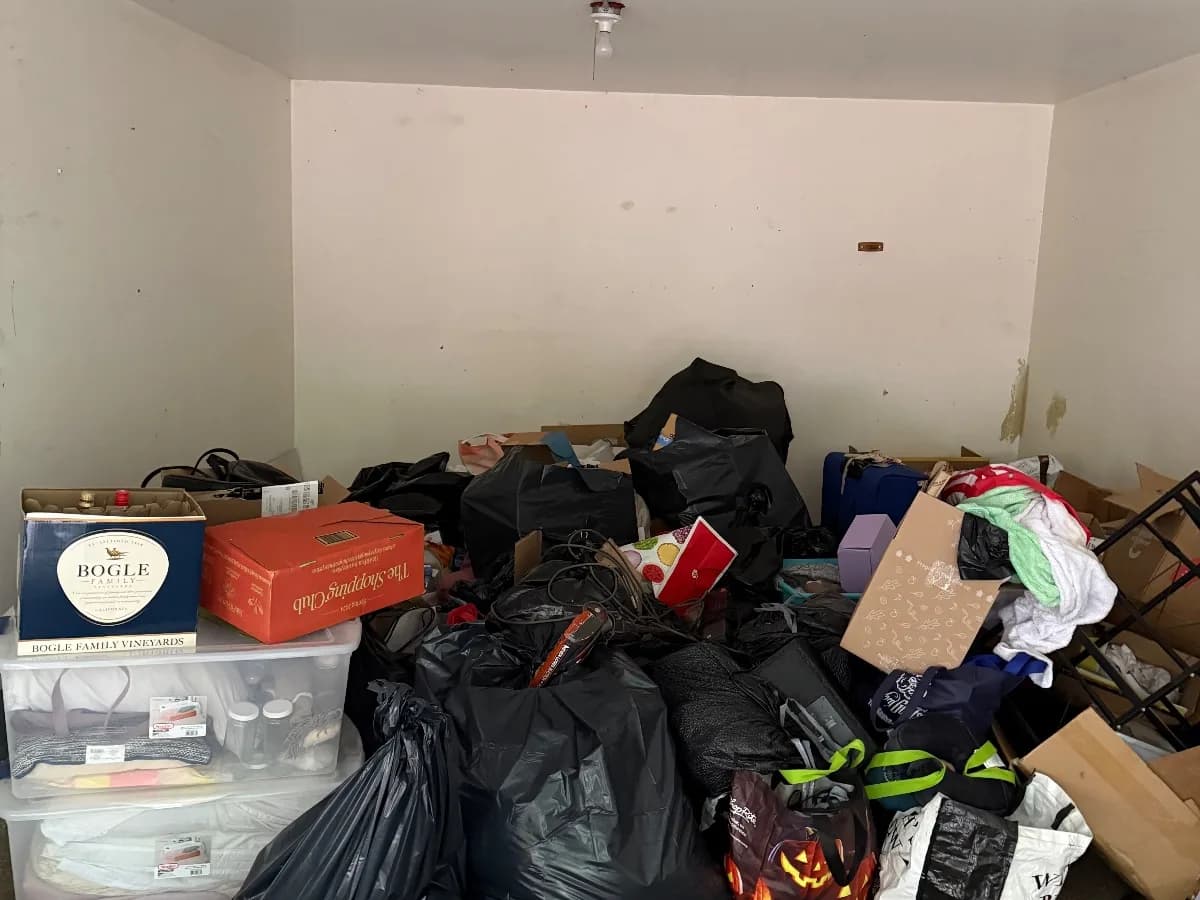 Household junk and bagged items in a Manchester garage before removal